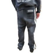 Person wearing a black tracksuit with visible branding on a white background