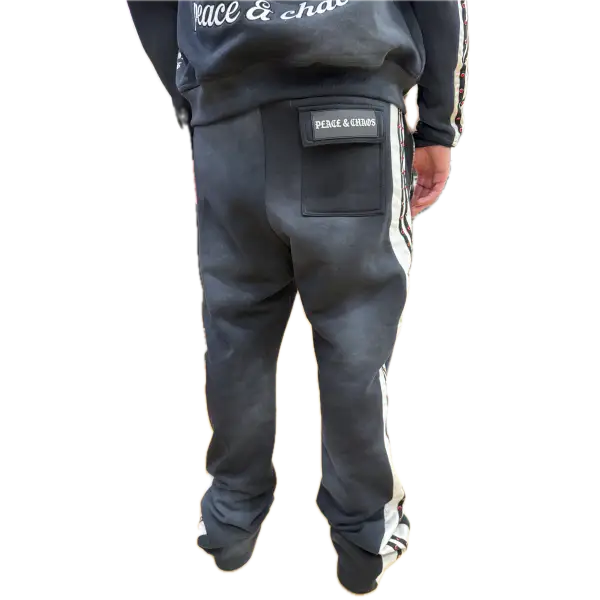 Person wearing a black tracksuit with visible branding on a white background